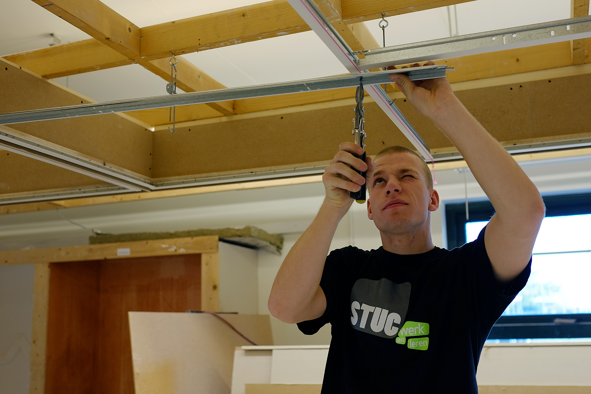 Een plafond- en wandmonteur is geconcentreerd aan het werk
